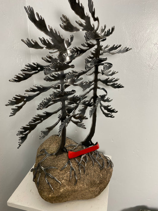 Metal windswept trees with canoe on granite