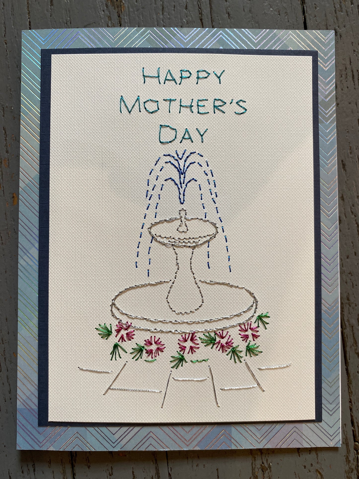 Handmade Mother's Day card with embroidered design of a fountain and flowers. Hand Stitched Greeting Card