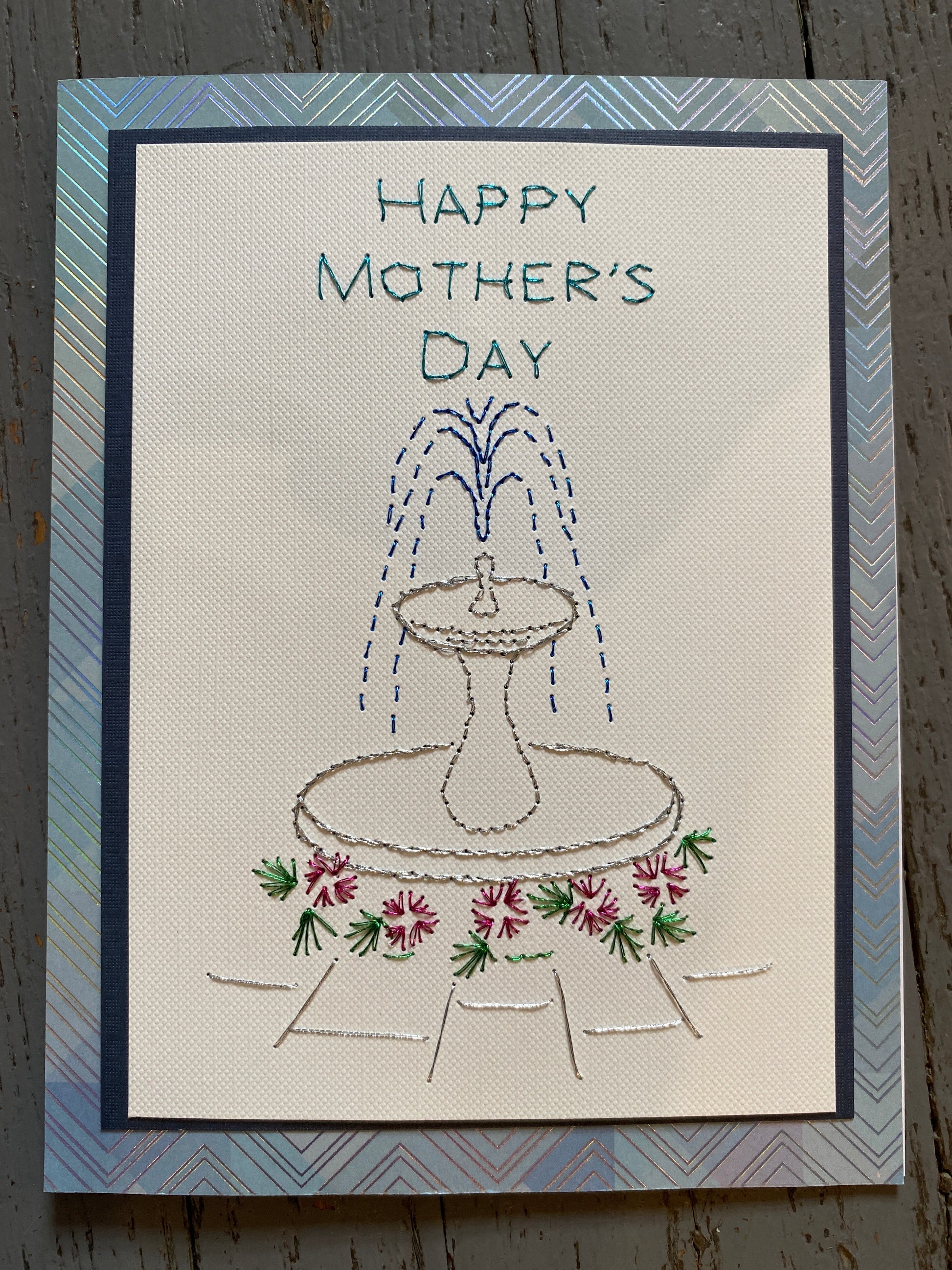 Handmade Mother's Day card with embroidered design of a fountain and flowers. Hand Stitched Greeting Card