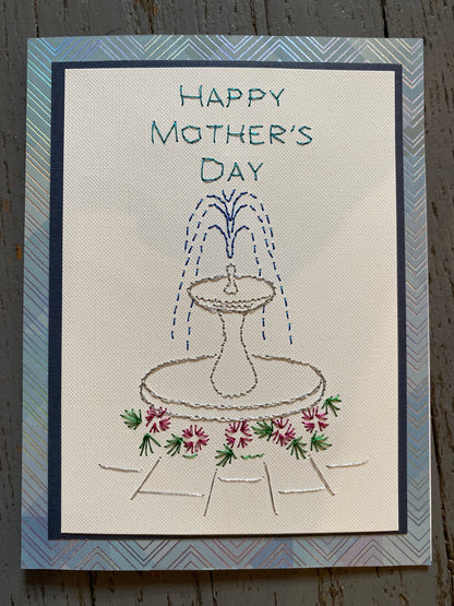 Handmade Mother's Day card with embroidered design of a fountain and flowers. Hand Stitched Greeting Card