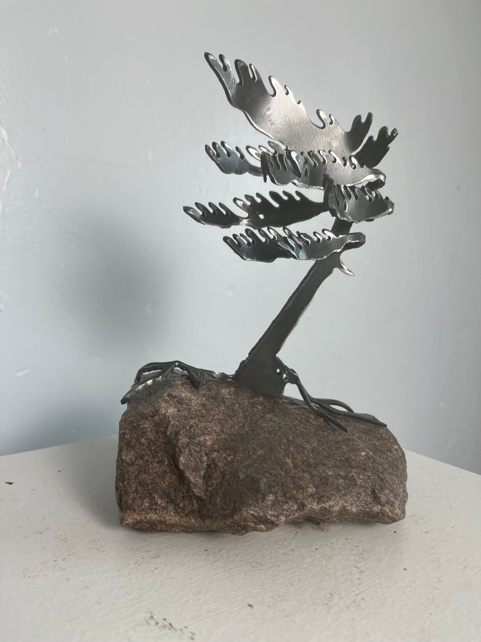 Cathy mark windswept metal pine tree on stone 