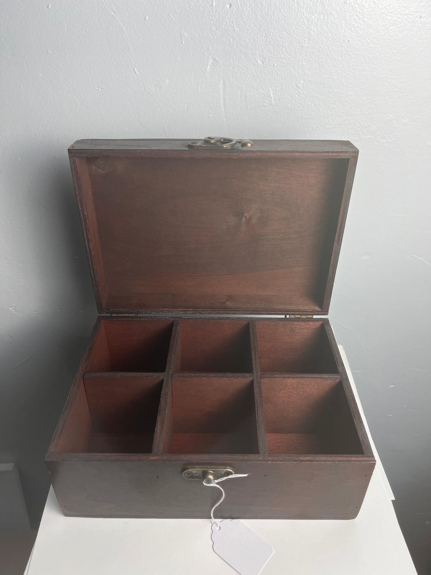 Wooden tea box with open lid on a gray background