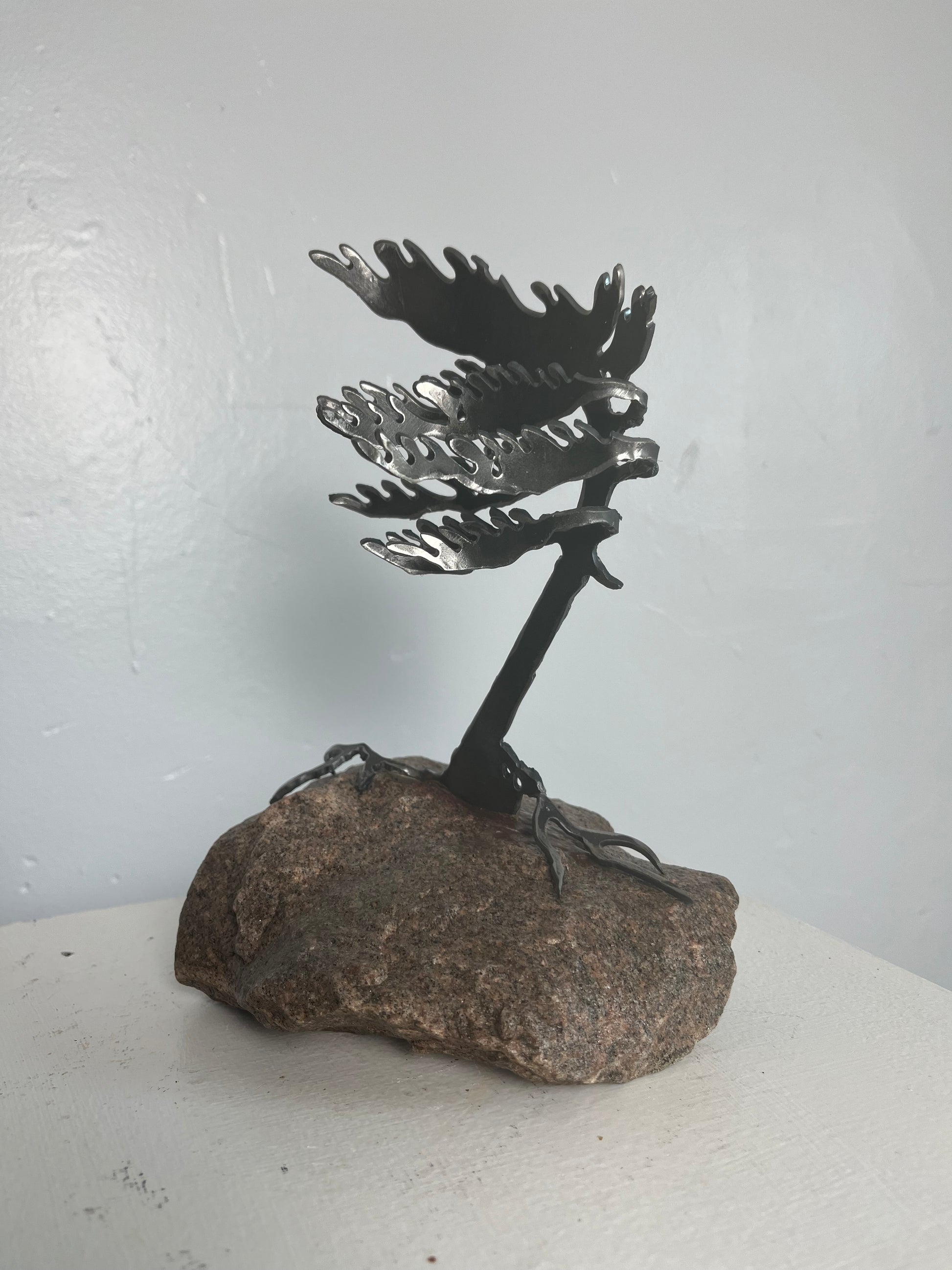 Cathy mark windswept metal pine tree on stone 