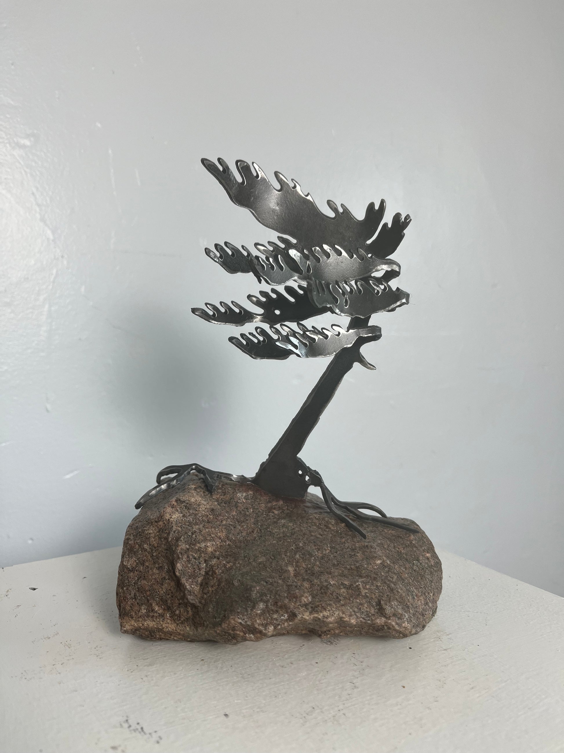 Cathy mark windswept metal pine tree on stone 