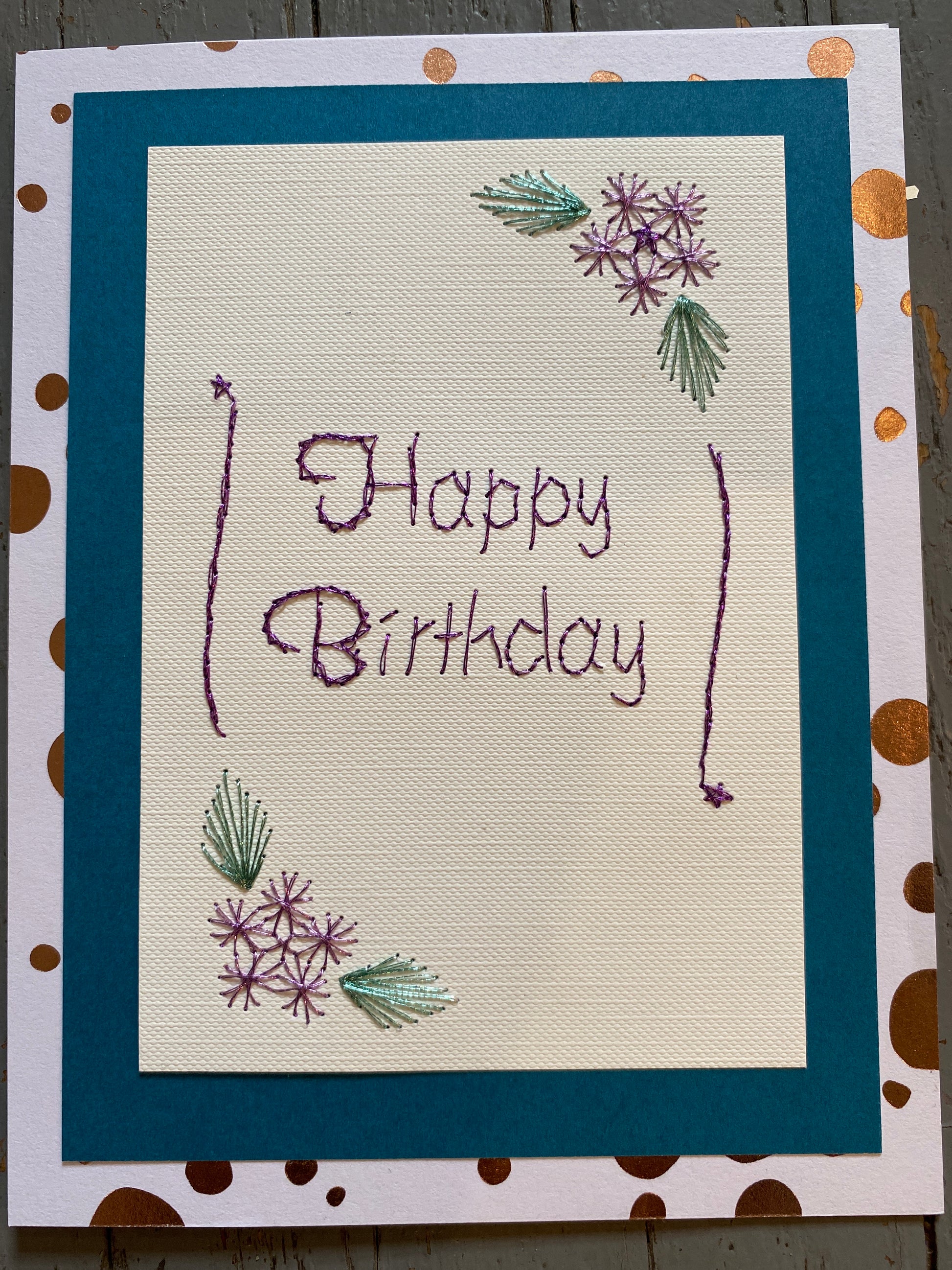Handmade birthday card with embroidered text and floral designs on a polka dot border. Hand Stitched Greeting Card