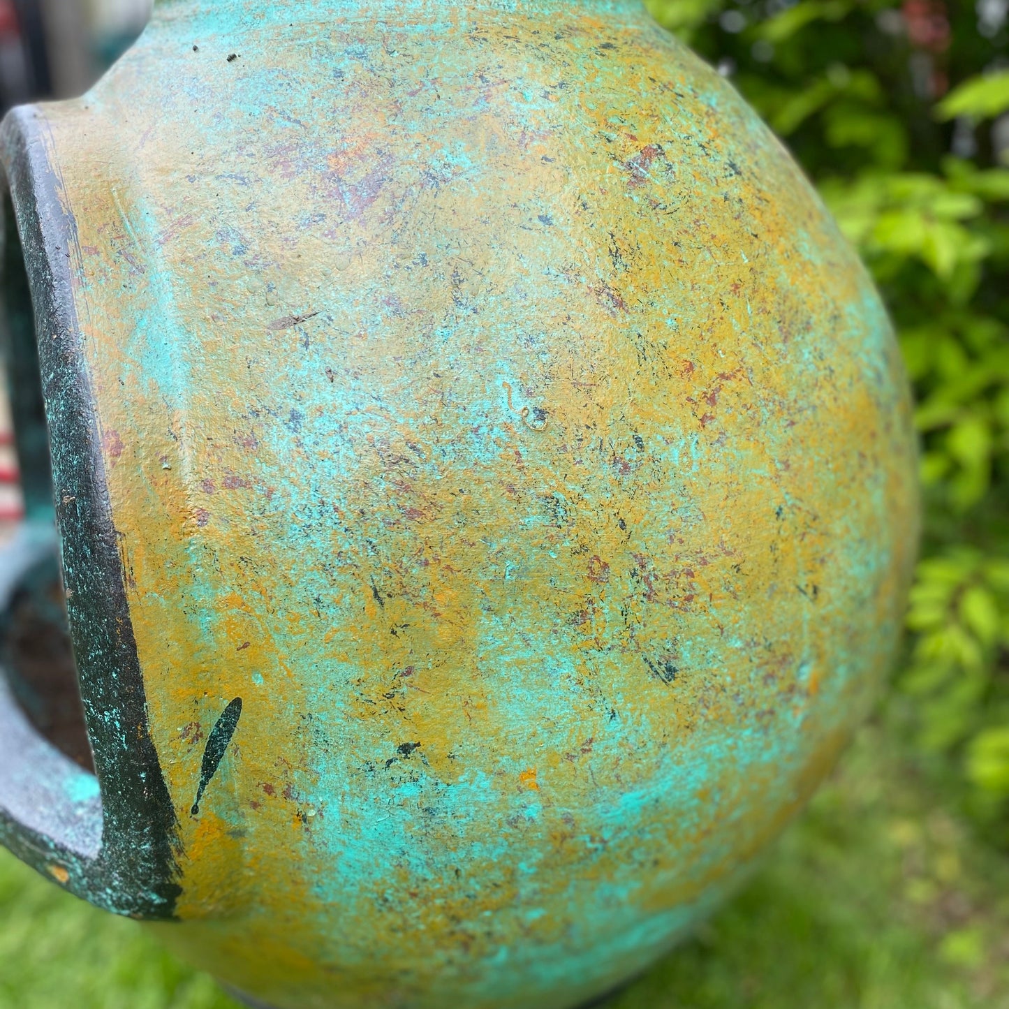 Close-up of a greenish-brown clay chiminea