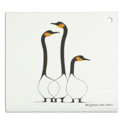 White eco dish cloth printed with Benjamin Chee Chee's Friends artwork of three geese with black necks and orange beaks.