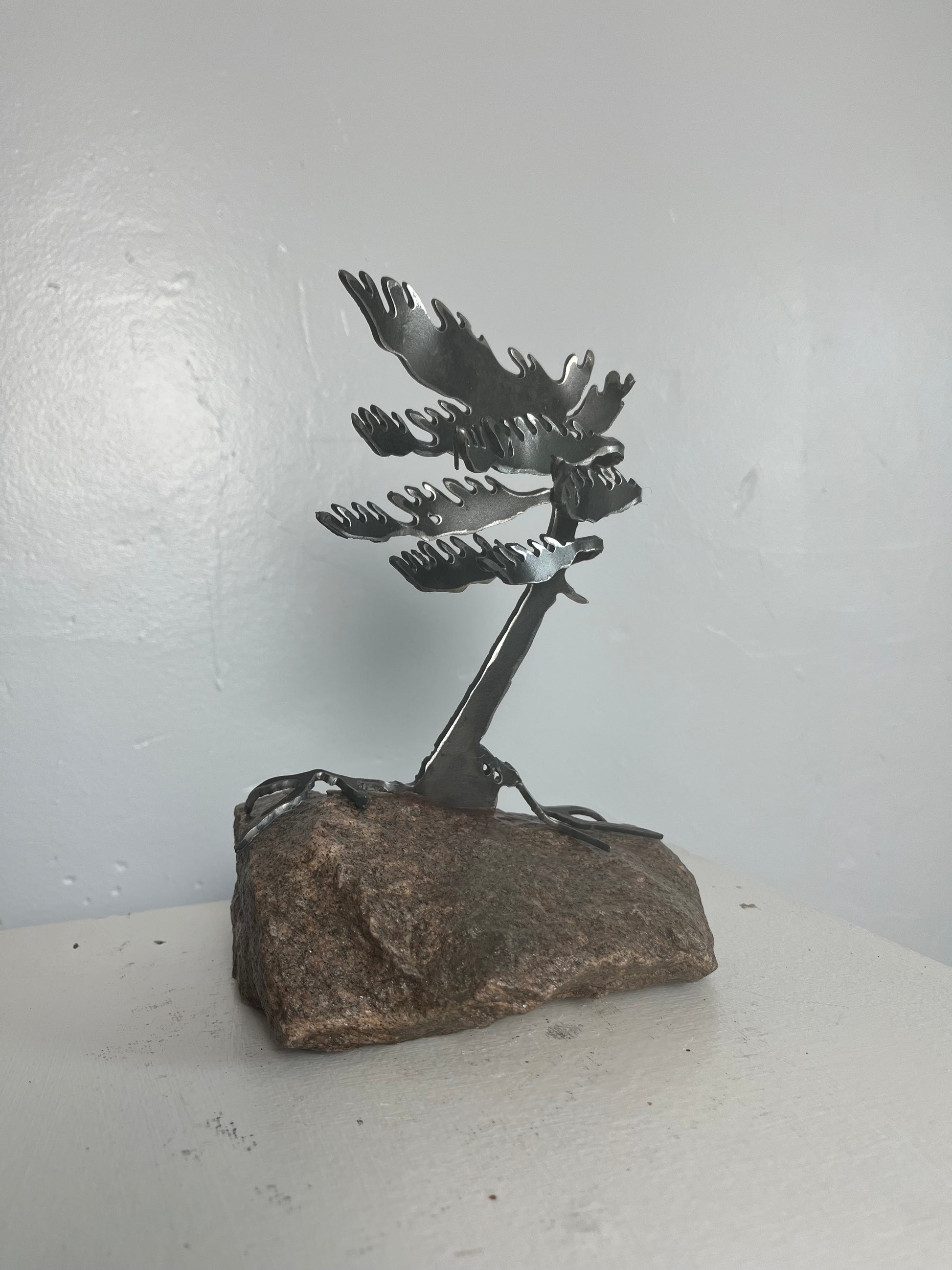 Cathy mark windswept metal pine tree on stone 