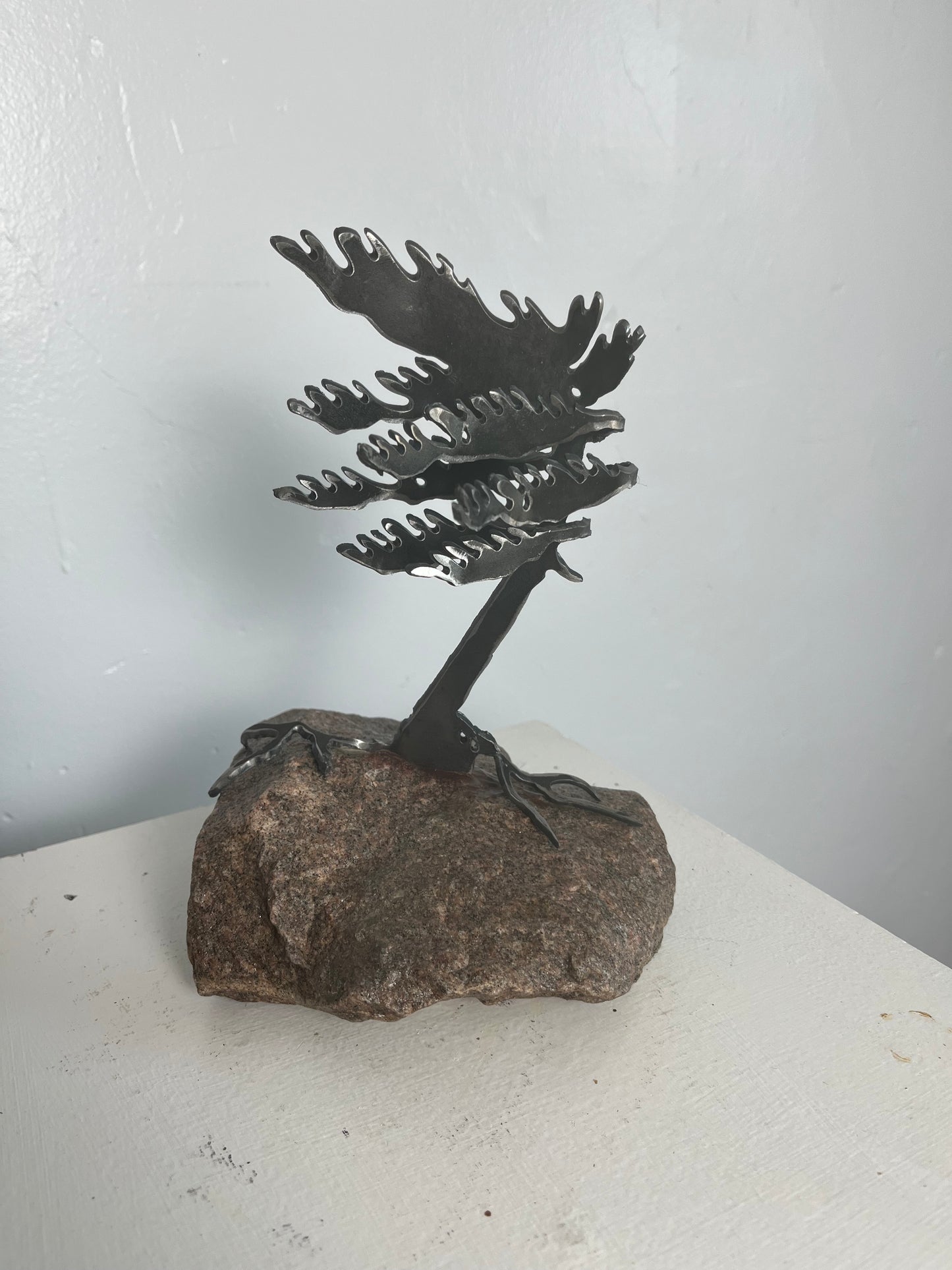 Cathy mark windswept metal pine tree on stone 