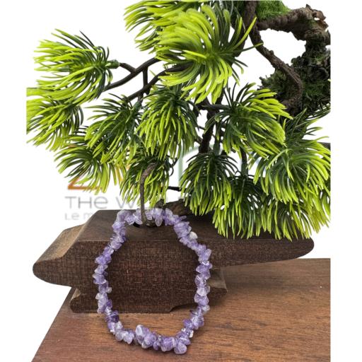 Amethyst bracelet on a wooden surface with a plant in the background