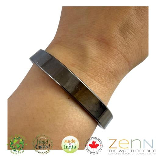 Black copper bracelet on a wrist with 'ZEN' branding and certification logos.