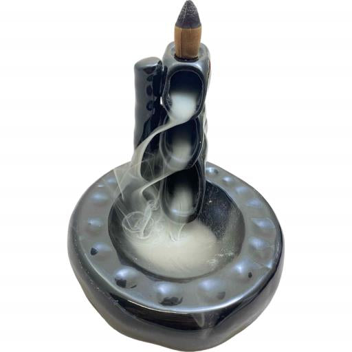 Backflow incense burner with smoke on a white background