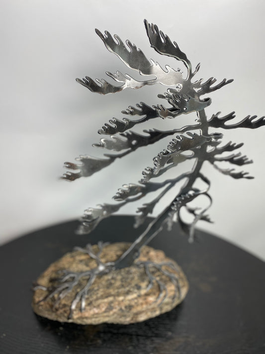 Metal windswept tree on granite