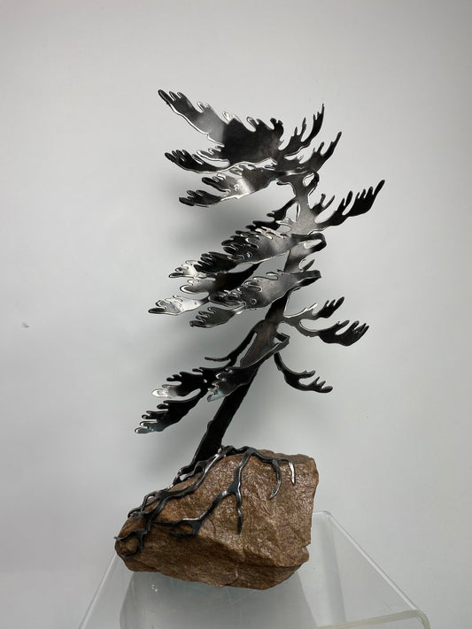 Metal windswept tree on granite