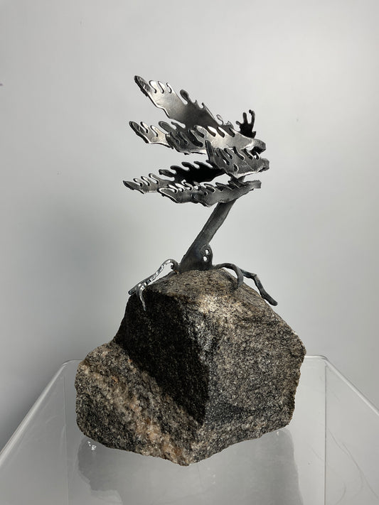 Metal windswept tree on granite