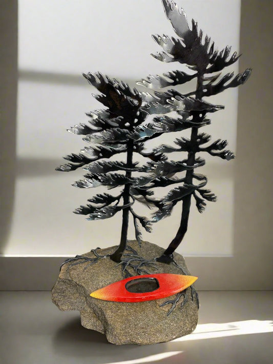 Metal windswept tree with kayak on granite