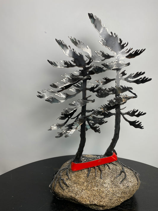 Metal windswept trees with canoe on granite