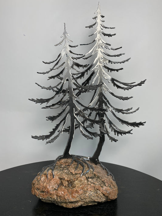 Metal spruce trees on granite